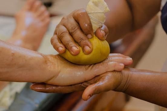 Warm herbal poultice being pressed along the arm to relieve joint pain